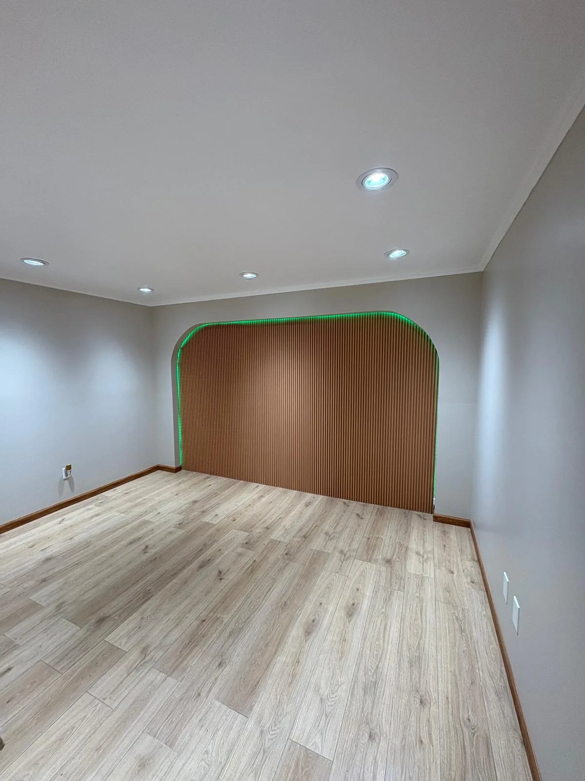 Completed interior feature wall with wood finish and accent lighting